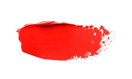 Photo of Red oil paint stroke on white background, top view