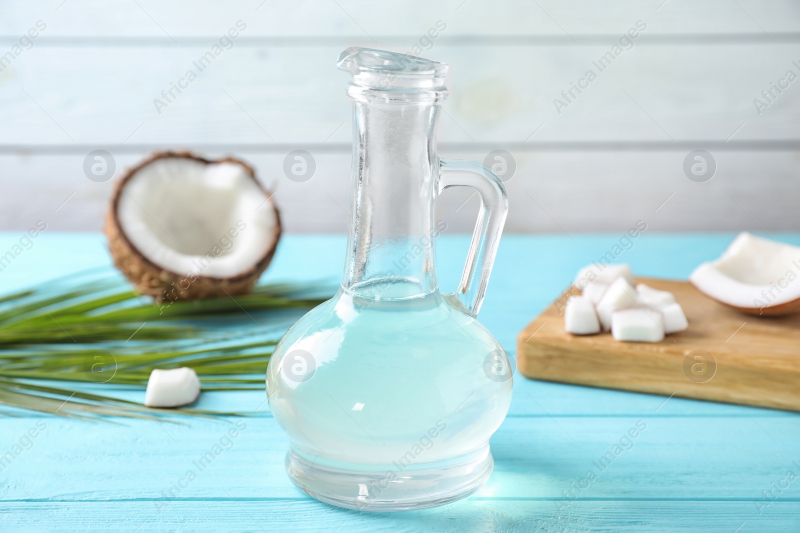 Photo of Coconut oil on light blue wooden table