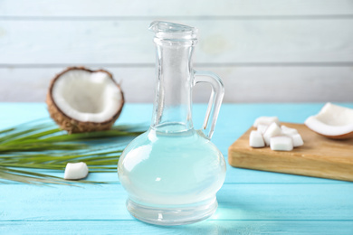 Photo of Coconut oil on light blue wooden table