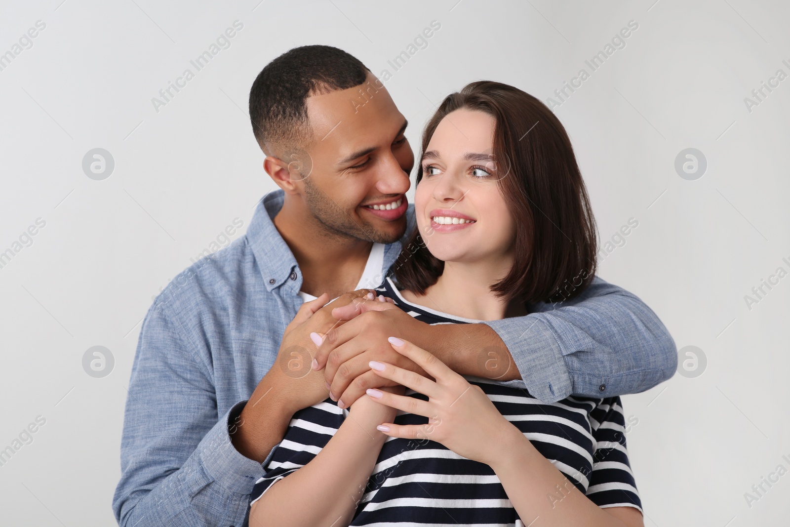 Photo of Dating agency. Man hugging his girlfriend indoors