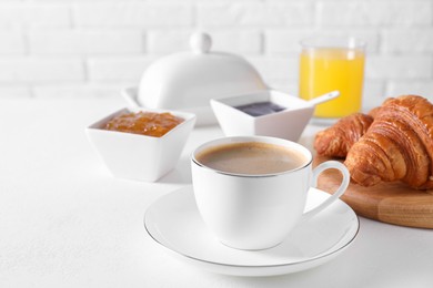 Photo of Fresh croissants, jams and coffee on white table. Tasty breakfast