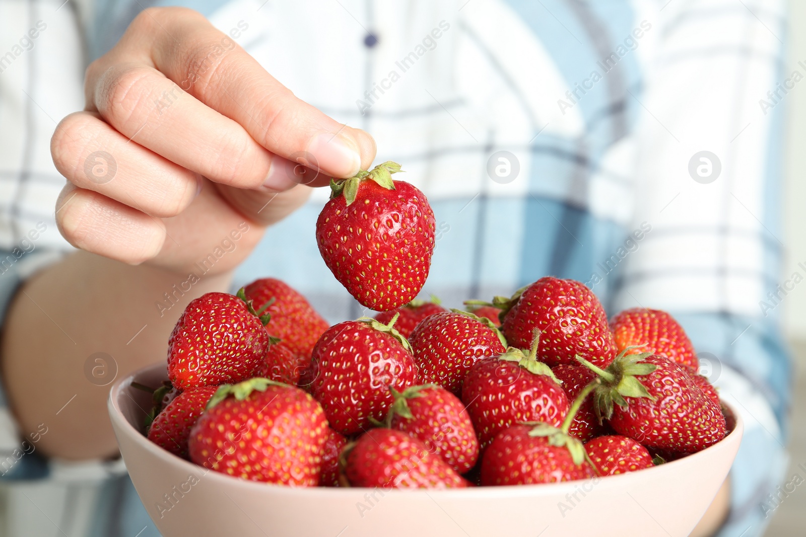 Photo of Woman holding bowl with tasty fresh strawberries, closeup