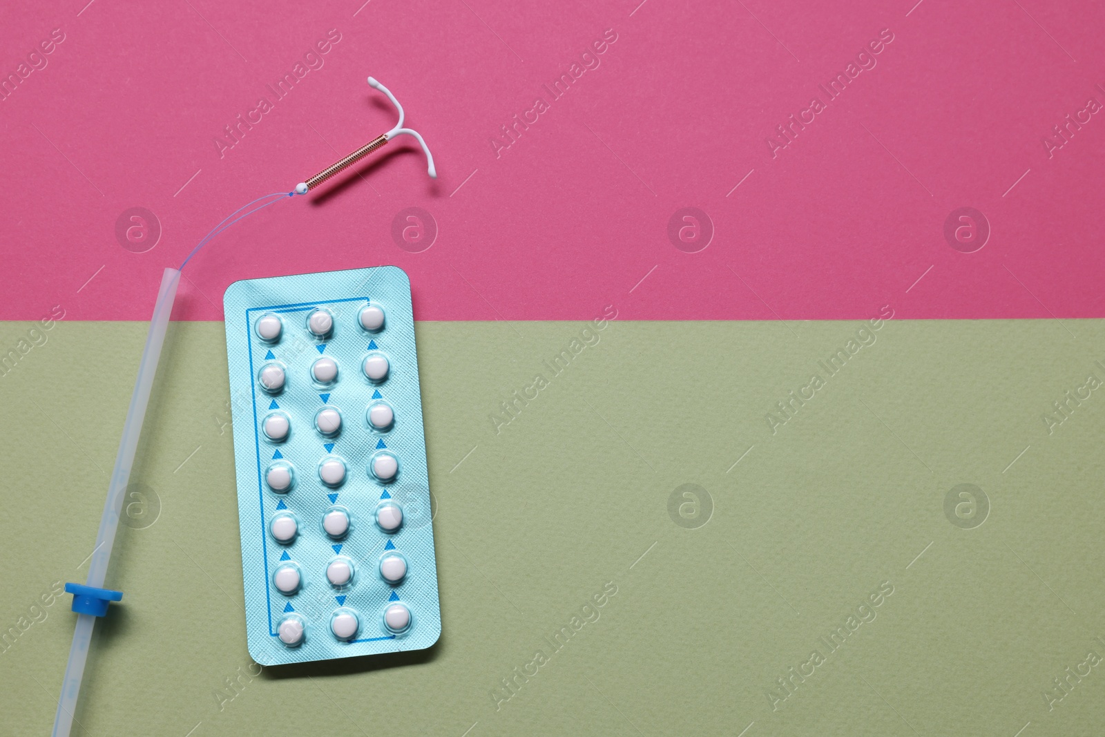 Photo of Birth control pills and intrauterine device on color background, flat lay and space for text. Choosing method of contraception