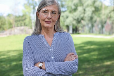 Portrait of beautiful senior woman in glasses outdoors