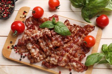 Photo of Slices of tasty fried bacon with different spices and tomatoes on wooden table, flat lay