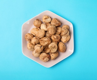 Photo of Plate with dried figs on color background, top view. Healthy fruit