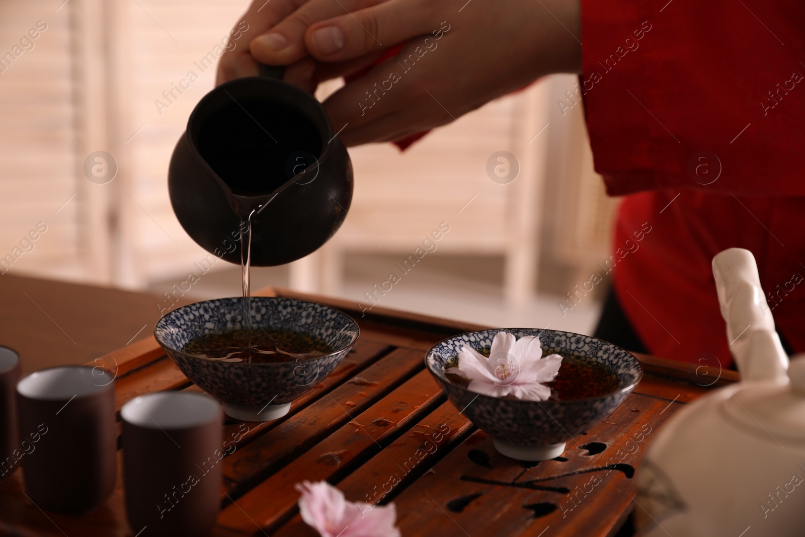 Photo of Master conducting traditional tea ceremony at table, closeup