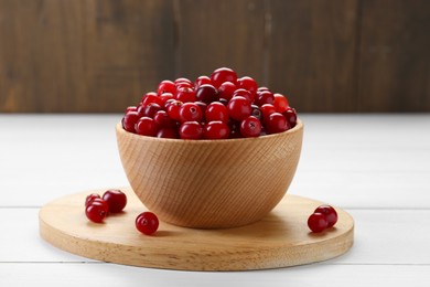 Photo of Fresh ripe cranberries in bowl on white wooden table, closeup