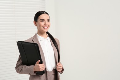Photo of Beautiful real estate agent with documents indoors, space for text