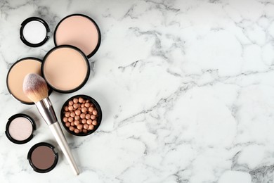 Flat lay composition with makeup brushes on white marble table, space for text