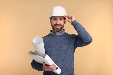 Photo of Architect in hard hat with draft and folder on beige background