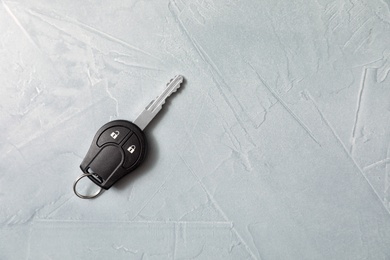 Car key on grey background, top view. Space for text