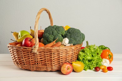 Assortment of fresh vegetables and fruits on white wooden table