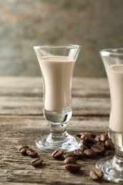 Photo of Coffee cream liqueur in glasses and beans on wooden table