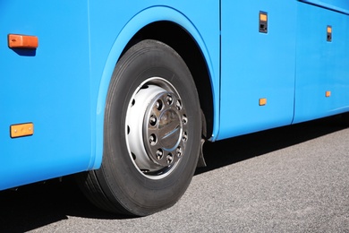 Modern blue bus on road, focus on wheel. Passenger transportation
