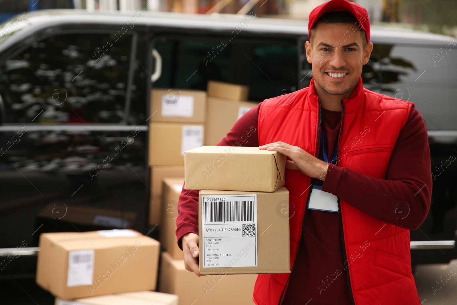 Photo of Courier with parcels near delivery van outdoors