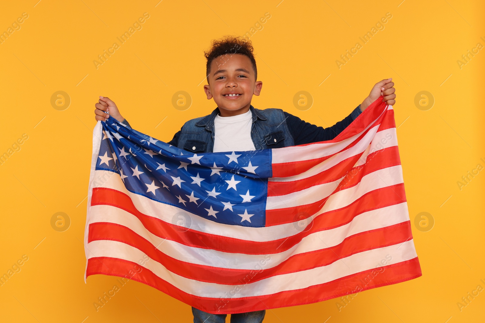 Photo of 4th of July - Independence Day of USA. Happy boy with American flag on yellow background