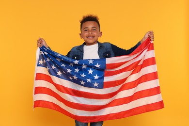 4th of July - Independence Day of USA. Happy boy with American flag on yellow background