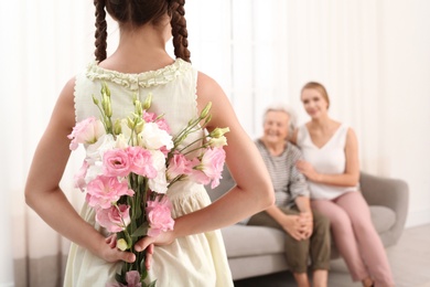 Photo of Girl congratulating her mom and grandmother in living room, closeup