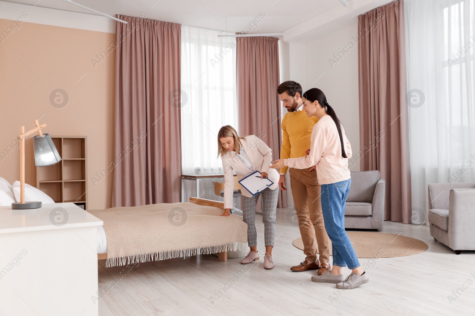 Photo of Real estate agent showing new apartment to couple