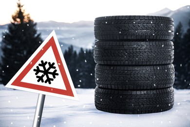 Set of winter tires and road sign outdoors