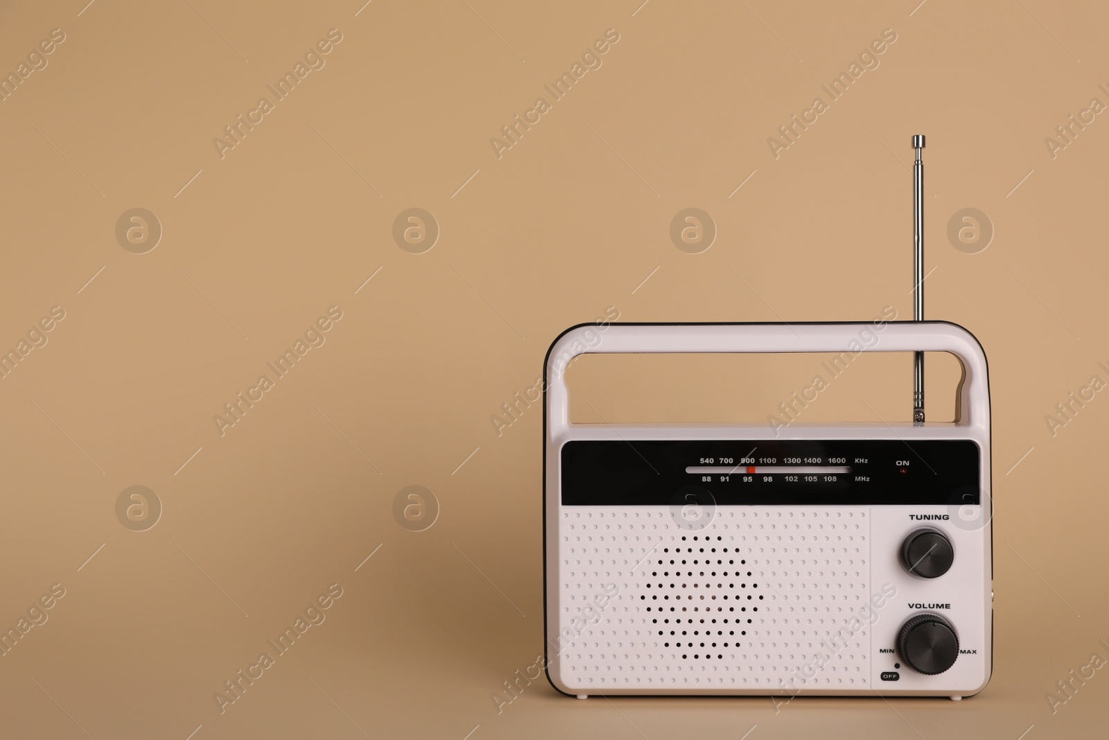 Photo of Portable retro radio receiver on beige background. Space for text