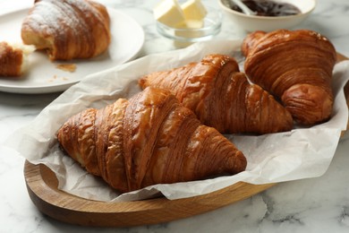 Tasty croissants on white marble table, closeup