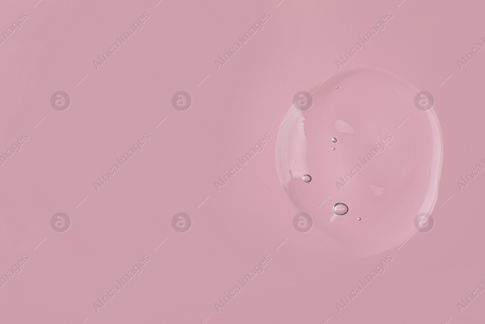 Photo of Sample of cleansing gel on pink background, top view with space for text. Cosmetic product