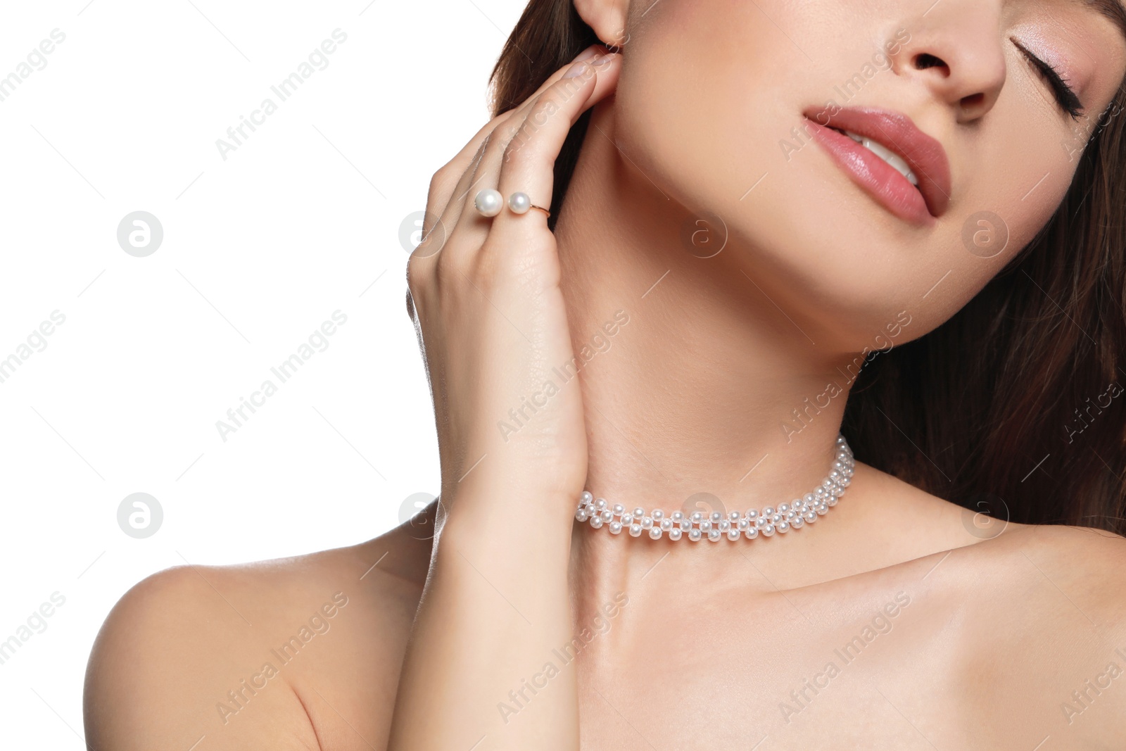 Photo of Young woman wearing elegant pearl jewelry on white background, closeup