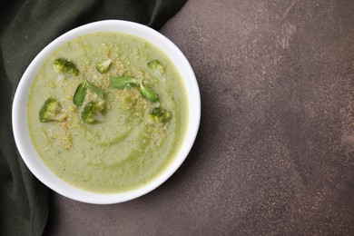 Delicious broccoli cream soup on grey table, top view. Space for text