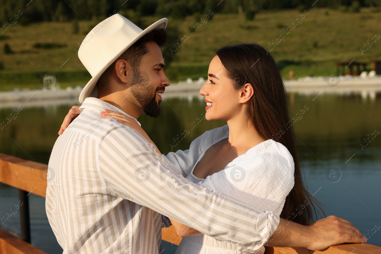 Photo of Romantic date. Beautiful couple spending time together near lake