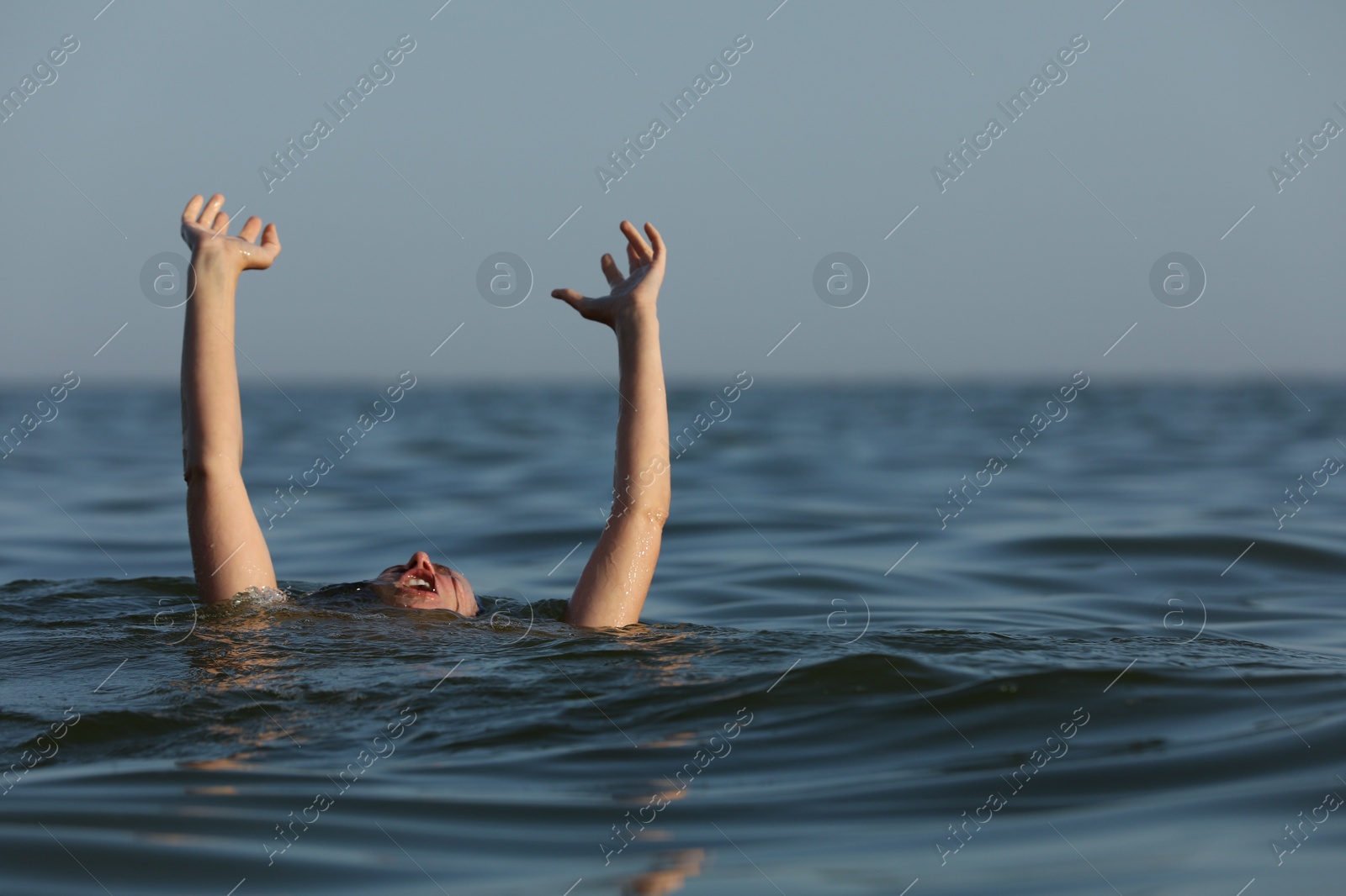 Photo of Drowning woman reaching for help in sea