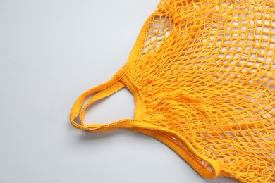 Photo of Orange string bag on light grey background, top view
