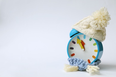 Photo of Alarm clock in hat on white background. New Year countdown