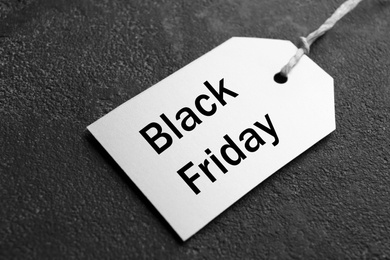 Photo of White blank tag on grey stone background, closeup. Black Friday concept