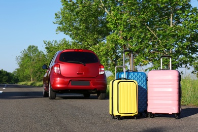 Color suitcases near family car on highway. Summer vacation