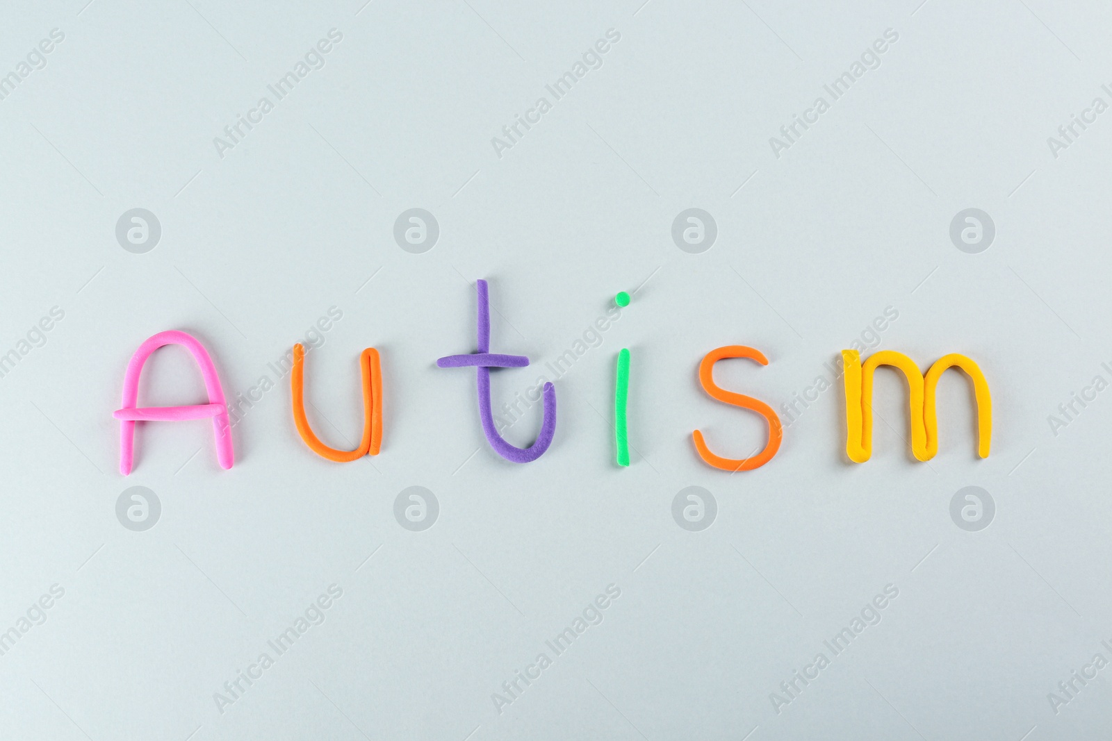 Photo of Word Autism made with colorful plasticine on white background, top view