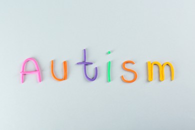 Word Autism made with colorful plasticine on white background, top view