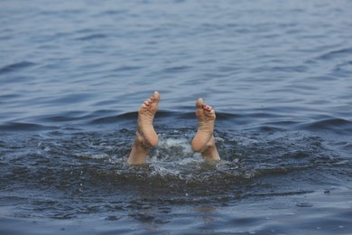 Photo of Woman drowning in sea, closeup of feet