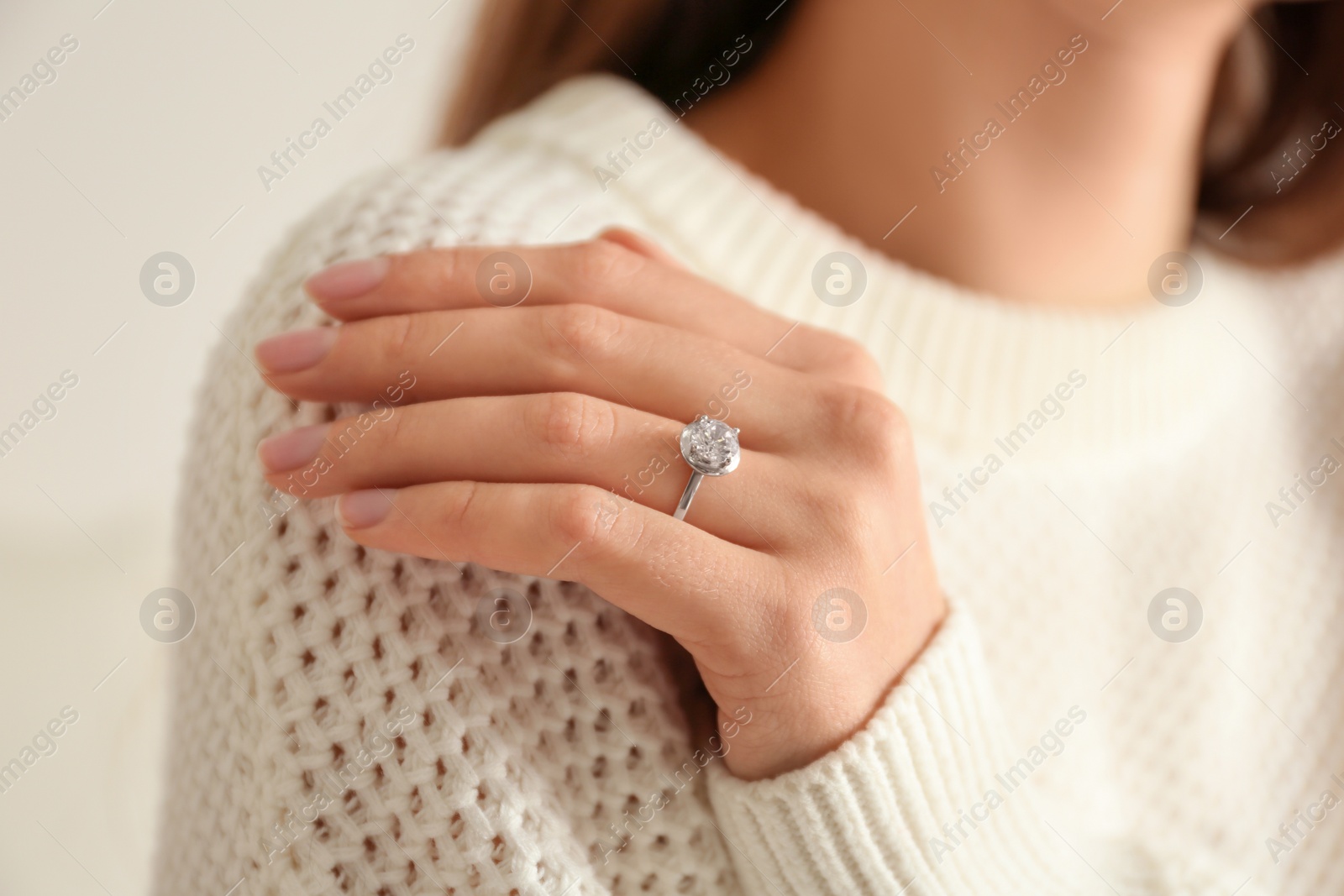 Photo of Young woman wearing beautiful engagement ring, closeup