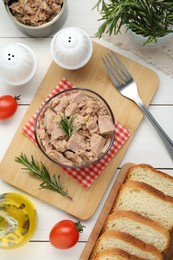 Bowl with canned tuna and products on white wooden table, flat lay