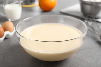 Glass bowl with batter on grey table, closeup