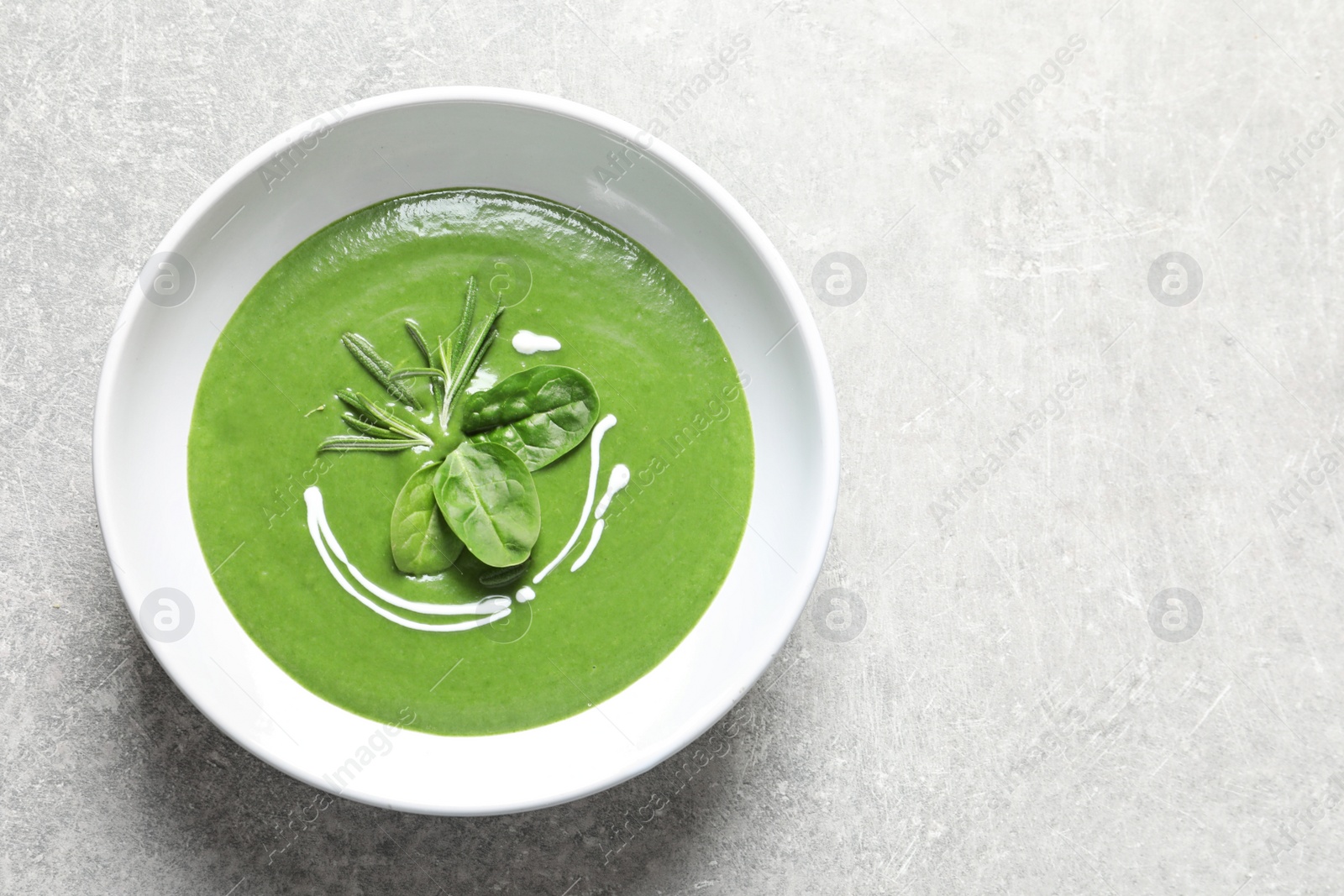 Photo of Fresh vegetable detox soup made of spinach in dish and space for text on table, top view