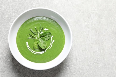 Photo of Fresh vegetable detox soup made of spinach in dish and space for text on table, top view