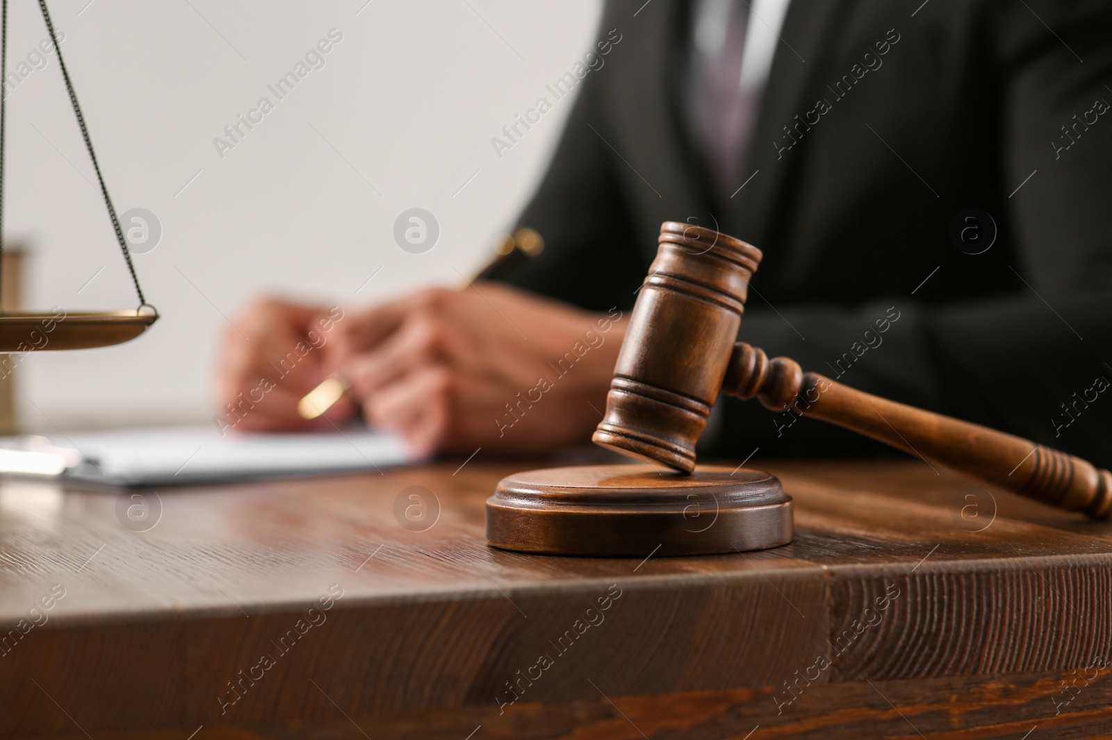 Photo of Law and justice. Closeup of judge working at wooden table, focus on gavel