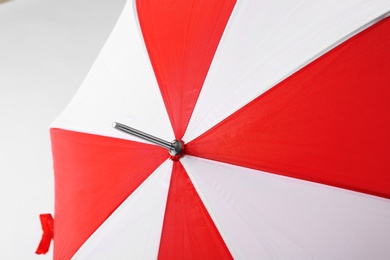 Bright red and white umbrella on light background, closeup