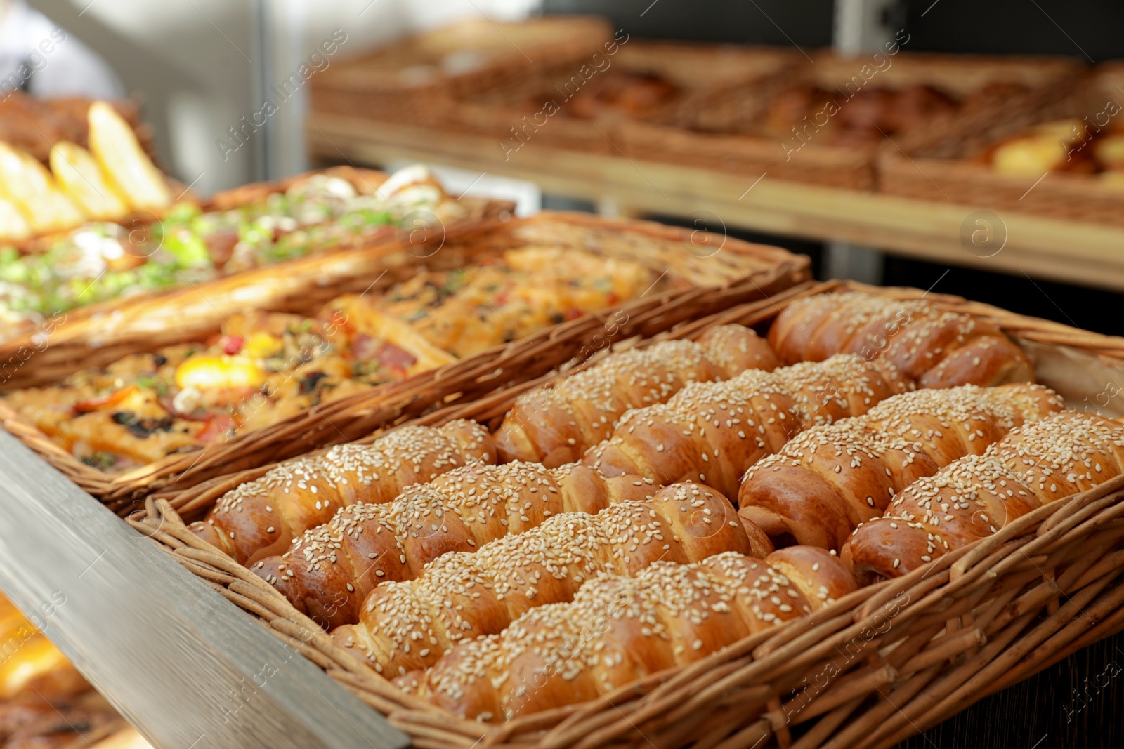 Photo of Wicker trays with fresh bakery products in store