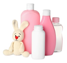 Photo of Bottles of baby cosmetic products and toy bunny on white background