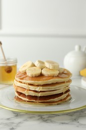 Photo of Delicious pancakes with bananas and honey on white marble table. Space for text