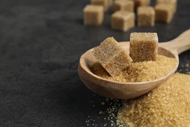 Photo of Spoon with brown sugar cubes on grey table, closeup. Space for text